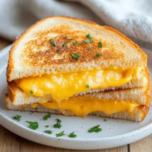 Golden Air Fryer Grilled Cheese sandwiches on a white plate, melted cheese oozing, warm and crispy